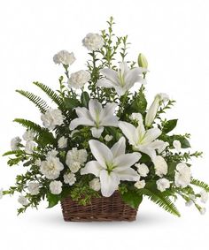 a basket filled with white flowers and greenery