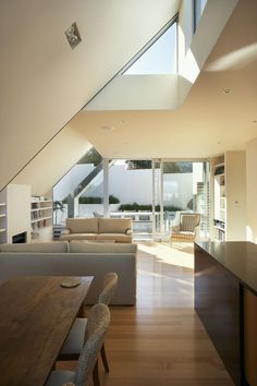 a living room filled with furniture next to a kitchen and dining room table on top of a hard wood floor