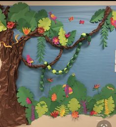 a bulletin board with paper flowers and leaves on the bottom, an image of a tree