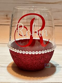 a wine glass with the word robin painted on it and beaded trim around the bottom