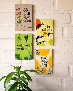 three canvases hanging on the wall above a potted plant