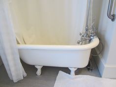 a white bath tub sitting next to a shower curtain