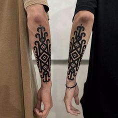 two people holding hands with tattoos on their arms and arm, both wearing matching bracelets