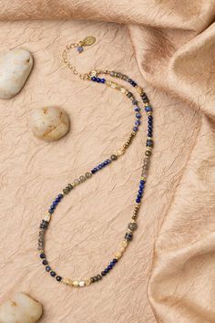 Discover the vibrant and stunning colors of the Blue Moon Collection in this eclectic necklace! Gold Filled (Lead & Nickel Free) Lapis Lazuli, Pyrite, Sodalite, Labradorite, Mother Of Pearl 16.5-18.5" adjustable length, with gold filled lobster claw clasp We hand select our natural materials, thus there may be slight variations in color and/or size that will not detract from the overall aesthetic. Our unique handcrafted designer jewelry for women is made in America, each design created individua Bohemian Lapis Lazuli Beaded Necklace With Gemstones, Bohemian Lapis Lazuli Crystal Necklace For Healing, Multicolor Lapis Lazuli Beaded Necklaces With Natural Stones, Multicolor Lapis Lazuli Beaded Necklace With Natural Stones, Multicolor Beaded Necklaces With Lapis Lazuli Stones, Multicolor Lapis Lazuli Natural Stones Beaded Necklace, Bohemian Lapis Lazuli Jewelry With Colorful Beads, Bohemian Lapis Lazuli Necklace For Healing, Bohemian Single Strand Lapis Lazuli Beaded Necklace