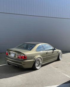 a tan car parked in front of a building