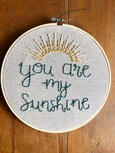 a cross stitch embroidery with the words you are my sunshine written in green on it