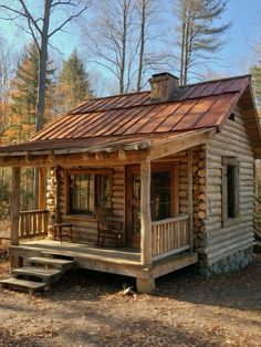 a small log cabin in the woods with a porch and steps leading up to it