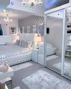 a bedroom with mirrored walls and white furniture