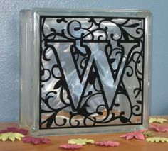 the letter w is made out of metal and sits on a table next to confetti