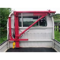 the back end of a white truck with red trim and metal bars on it's doors