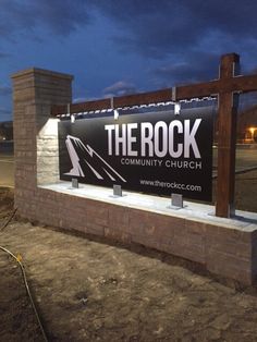 the rock community church sign is lit up at night