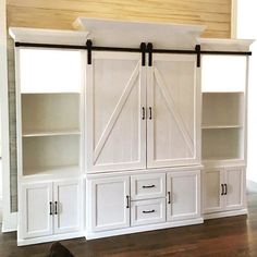 a white entertainment center with sliding doors on the front and back sides, in a living room