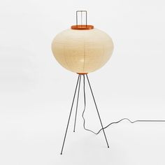 a lamp that is sitting on top of a tripod stand with an orange light