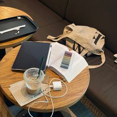 a wooden table topped with a laptop computer next to a cup of coffee and an open book