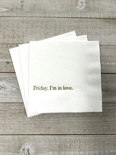 two napkins with the words friday, i'm in love on them sitting on top of a wooden table