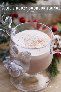 a close up of a drink in a glass cup on a table with christmas decorations