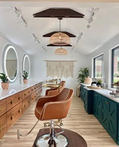 a hair salon with chairs and mirrors on the wall, lights hanging from the ceiling