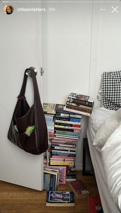 a room with a bed, books and a purse on the floor next to it