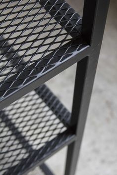 a black metal shelf sitting on top of a cement floor