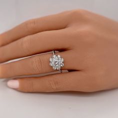 a woman's hand with a diamond ring on it