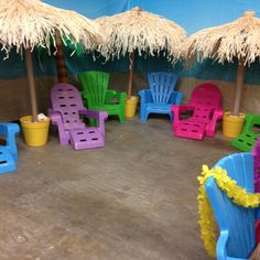 colorful lawn chairs and straw umbrellas are set up in a circle on the floor