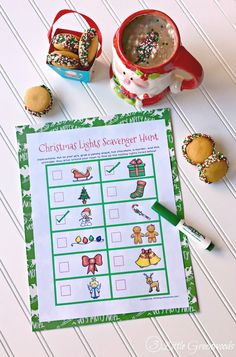 a cup of coffee and some cookies on a table with a printable christmas math game