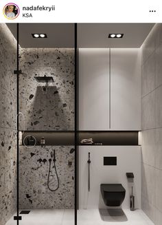 an image of a bathroom setting with black and white tiles on the walls, toilet and shower