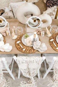 the table is set with white dishes and place settings