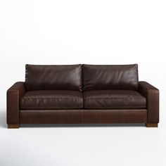 a brown leather couch sitting on top of a white floor