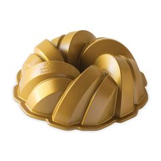 a golden bundt cake pan on a white background