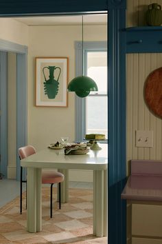 a dining room table and chairs in front of a window with blue trim on the walls