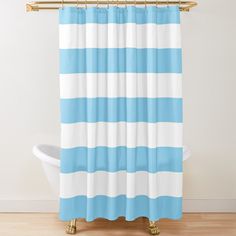 a blue and white striped shower curtain hanging on a wall next to a bathtub