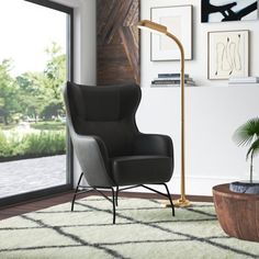 a living room with a black chair and white rug