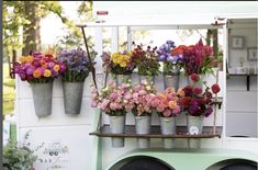 an assortment of colorful flowers are on display at a flower shop in front of a food truck