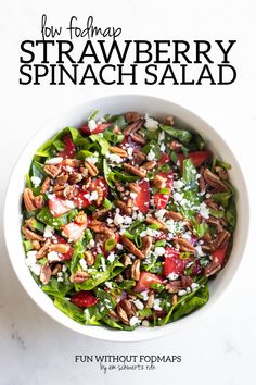 a white bowl filled with spinach salad on top of a table