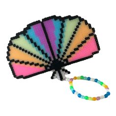 Add a touch of rainbow to your festival gear collection with this beautiful Glow in the Dark Perler Kandi Hand Fan Bracelet Wristlet. It is handcrafted with high-quality beads and features a beaded bracelet design that is perfect for any wrist size. The Byte Size Kandi brand ensures the best quality and design for your jewelry collection. This bracelet is perfect for anyone who loves to stand out in the crowd. The rainbow colors will glow in the dark and make you shine. The bracelet is perfect for any festival or party and will make a great addition to any costume. The beaded design is stylish and comfortable to wear all day long. Get your hands on this exclusive bracelet now! Adjustable Rainbow Stretch Bracelet For Festivals, Rainbow Rave Bracelets As Gift, Rainbow Beaded Bracelets For Rave Gift, Rainbow Beaded Bracelets For Gifts, Rave Style, Rainbow Colored Rave Style Beaded Bracelets For Gifts, Handmade Multicolor Rave Wristband, Multicolor Rave Wristband As Gift, Handmade Rave Stretch Bracelet As Gift, Multicolor Rave Stretch Bracelet Gift