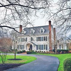 a large white house sitting on top of a lush green field