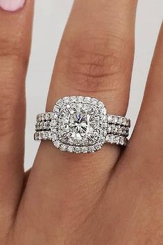 a woman's hand with two engagement rings on it