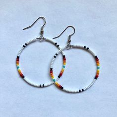 These handmade, beaded hoop, earrings come in a variety of colors. This is a gorgeous white sunset pattern. Perfect for all occasions and super comfortable to wear. These earrings are not heavy at all and can be worn comfortably all day. The earrings are 5 cm across. Every pair is unique and  may look somewhat different than the picture. I love making these earrings and hope you enjoy wearing them! Handmade White Heishi Beads Earrings, Bohemian Heishi Beaded Hoop Earrings, Bohemian Hoop Beaded Earrings With Heishi Beads, Bohemian Hoop Earrings With Heishi Beads, Bohemian White Hoop Earrings For Beach, Bohemian Heishi Beads Hoop Earrings, Dangle Hoop Earrings With Tiny Beads For Beach, Handmade Bohemian Hoop Beaded Bracelets, White Circular Jewelry For The Beach