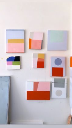 several different colored paintings hanging on the wall