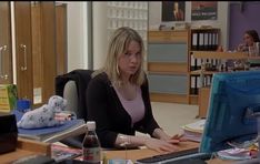 a woman sitting at a desk in front of a computer