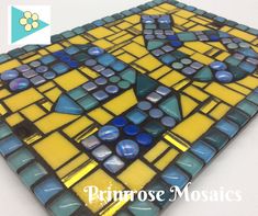 a yellow and blue mosaic tile is shown with the words primrose mosaics on it