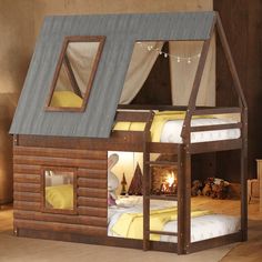 a child's wooden cabin bed with windows and curtains on the top bunk, next to a fire place