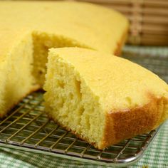 a cake that is sitting on a cooling rack with one slice cut out and ready to be eaten