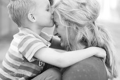 black and white photograph of a mother kissing her son