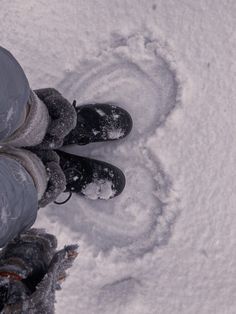 a person standing in the snow with their feet up