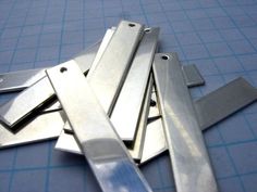 several pieces of metal sitting on top of a blue cutting mat next to each other