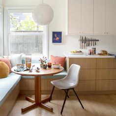 a kitchen table with two chairs next to it and a window in the back ground