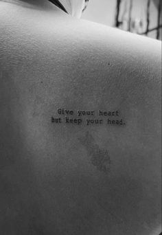 the back of a man's shoulder with an inscription on it that says give your heart but keep your head