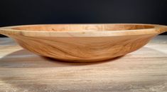 a wooden bowl sitting on top of a table